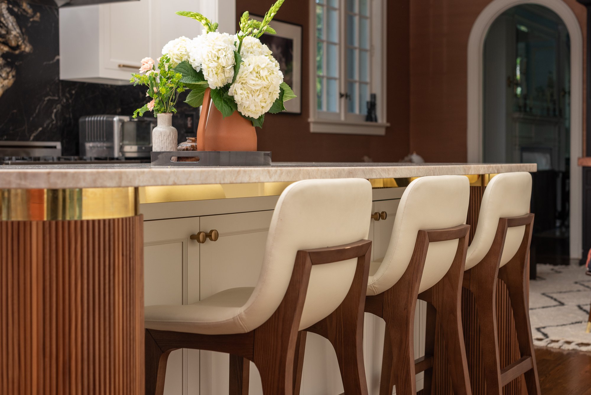 Modern Kitchen with Stools and Fluted Wood and Gold Details